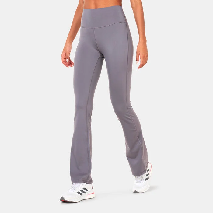 Woman wearing high-waisted adidas grey flared leggings designed for yoga, stretching, and everyday movement