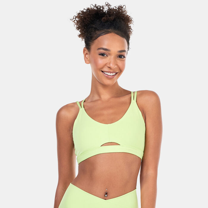 Woman wearing a light green adidas sports bra with a secure fit, suitable for yoga, pilates, and low-impact workouts